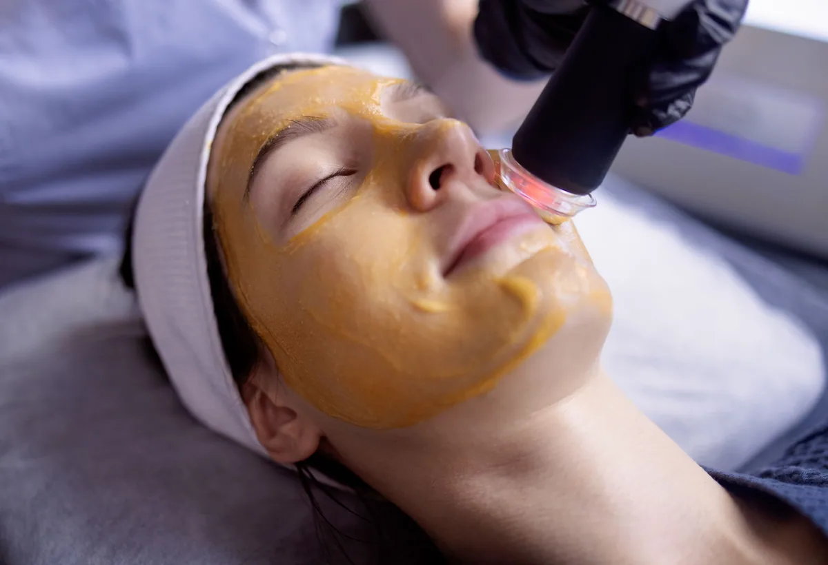 Klant met gesloten ogen en een ontspannen glimlach na een behandeling in de salon